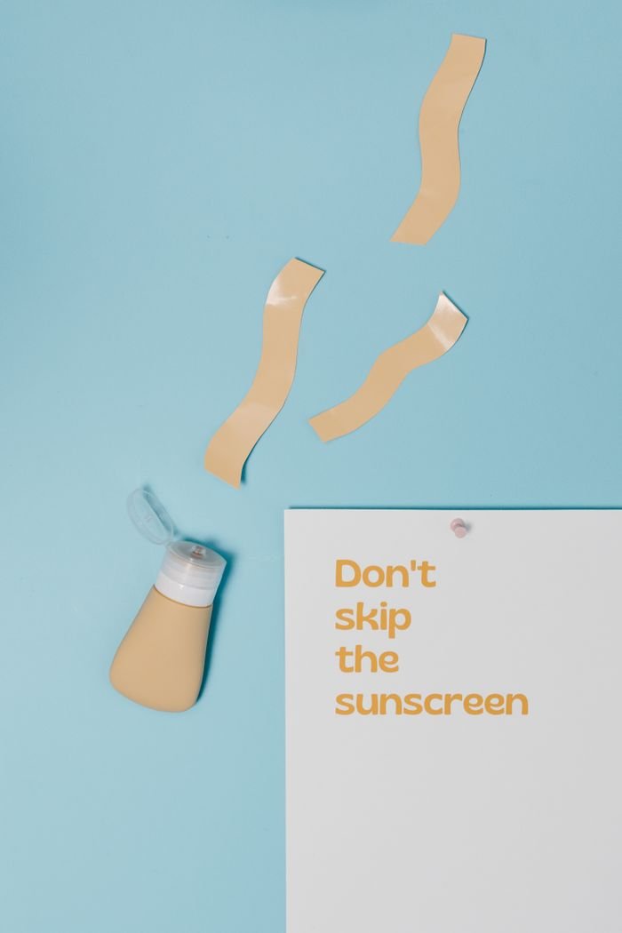 Minimalist flat lay design emphasizing the importance of sunscreen with a catchy slogan and bottle of sunscreen.